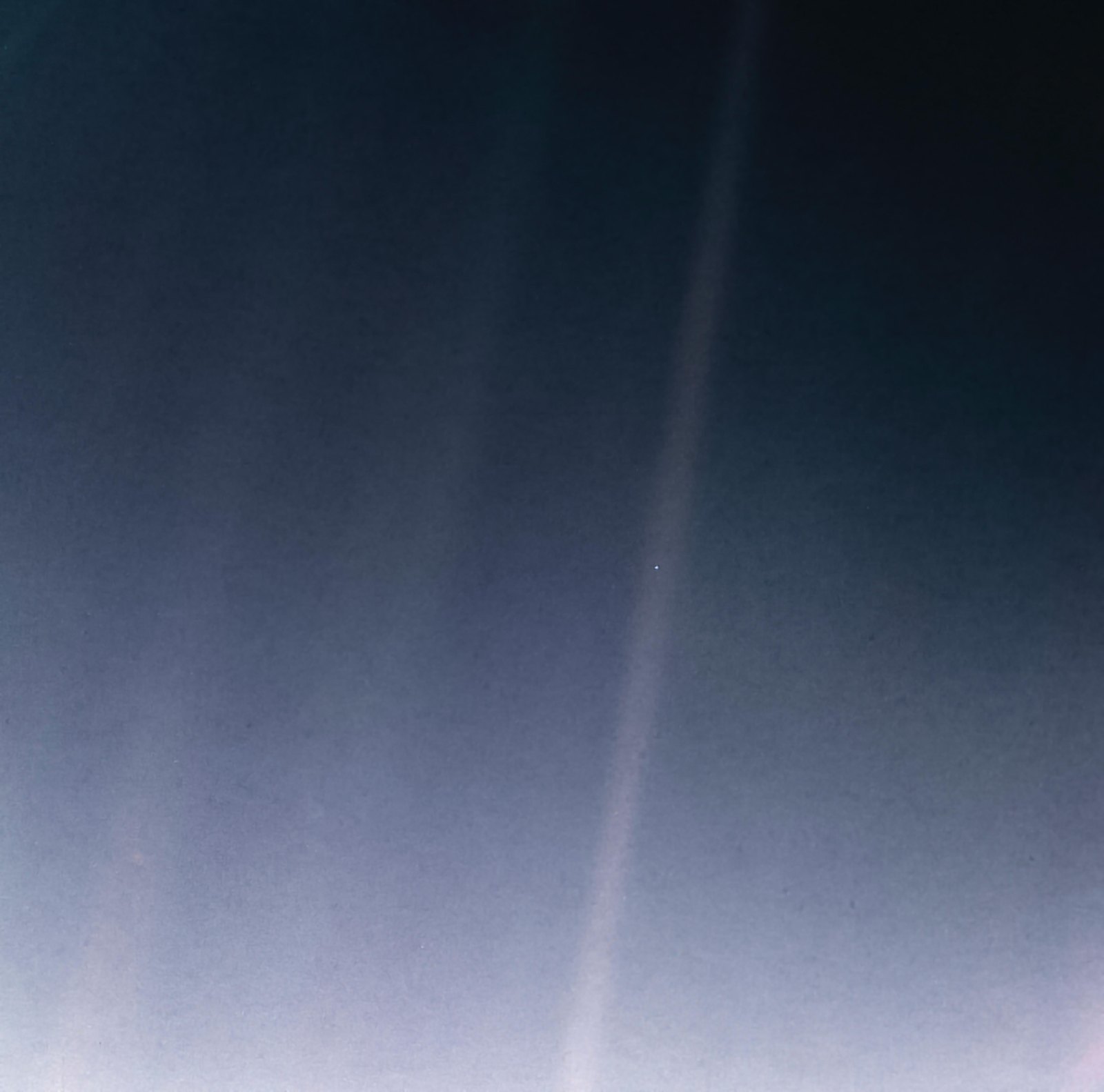 A dark sky crossed by faint bands of scattered sunlight. In one band sits a single tiny pale blue speck: Earth.